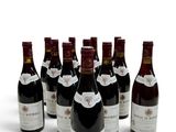six bouteilles de vin sont alignées sur une surface blanche