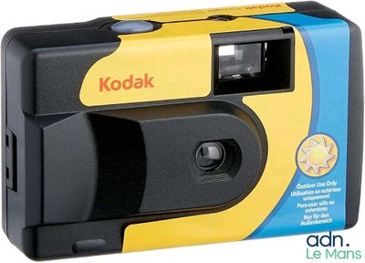 un appareil photo Kodak jaune et noir posé sur une boîte bleue et jaune