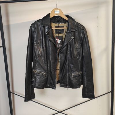 une veste en cuir noir suspendue à un portant dans une pièce