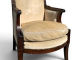 an upholstered chair with a beige upholstered seat and wood frame