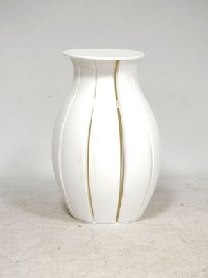 a white vase with a gold stripe on it