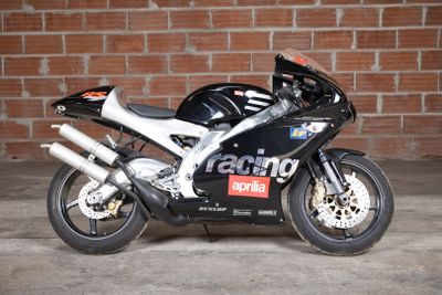 a black motorcycle parked in front of a brick wall