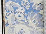 an open book with white lace on it