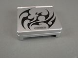 a small silver box with a black design on it