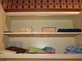 a shelf that has a lot of towels and other things on it