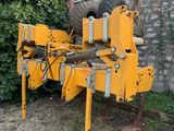 un gros plan d'une grosse machine jaune garée devant un mur de briques