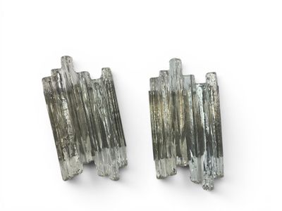 two pieces of silver colored quartz on a white surface