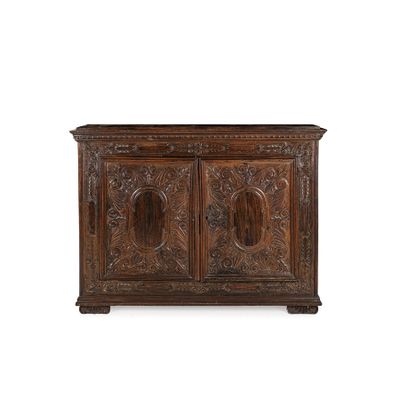 une vieille armoire en bois avec des sculptures et des gravures sur les portes