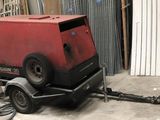 a red machine that is sitting on a trailer