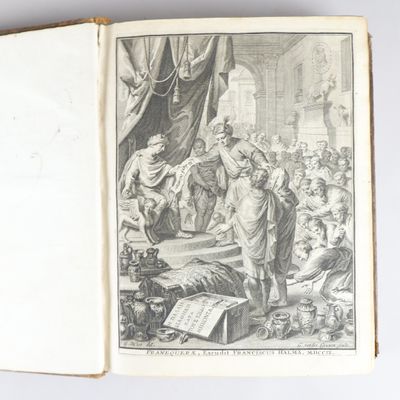un livre ouvert sur lequel figure le dessin d'un homme debout devant un groupe de personnes