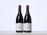 two bottles of wine sitting on top of a table next to each other