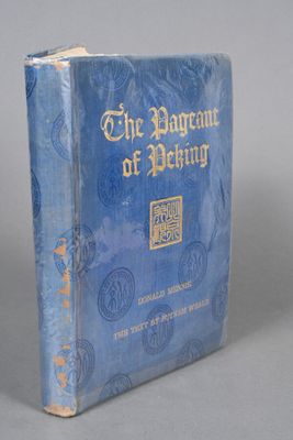 a blue book with gold writing on it sitting on a gray surface