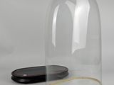 a glass clochet sitting on a table next to a cell phone