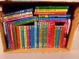 many books in a box that are stacked on top of each other