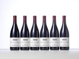 four bottles of wine are lined up on a table
