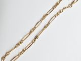 une paire de bracelets en chaîne en or sur fond blanc