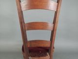 a wooden chair with a red seat on a gray background