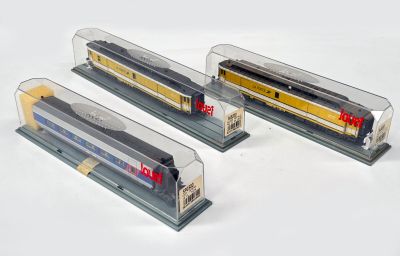 trois trains miniatures exposés dans une vitrine