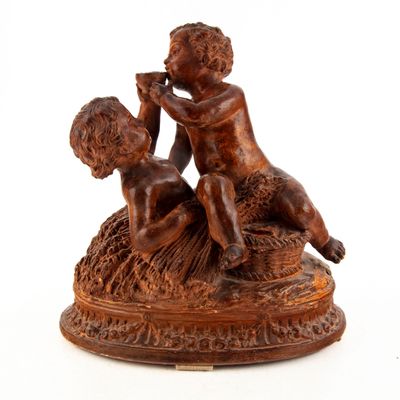 une statue représentant un garçon et une fille assis sur un rocher