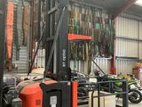 a forklift in a warehouse with lots of tools on the floor