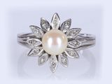 gros plan d'une bague en perles et diamants sur fond blanc