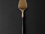 a close up of a spatula on a black surface
