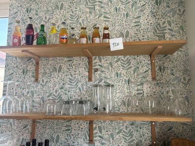 de nombreux verres et bouteilles sur les étagères de la cuisine