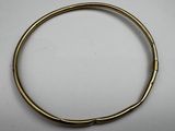 a gold bracelet with a metal clasp on a white surface