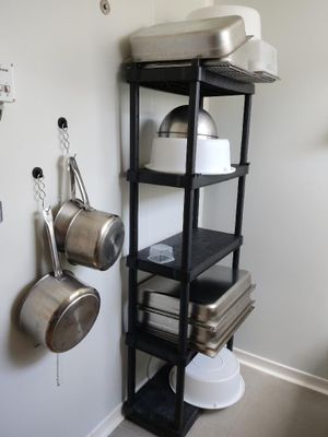 une étagère avec des casseroles et des poêles dans une cuisine