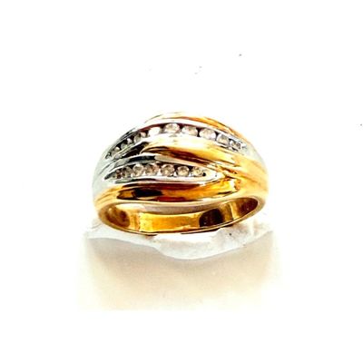 une bague en or sertie de diamants, posée sur une surface blanche