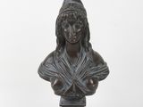 bronze bust of a woman with a hat on her head