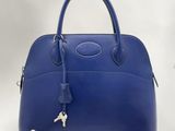 un sac à main en cuir bleu muni d'un cadenas sur la poignée