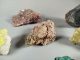 many different colored rocks on a white surface