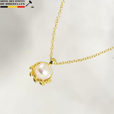 a gold necklace with a white pearl on a gold chain
