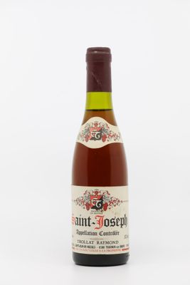 une bouteille de vin posée sur une table blanche