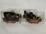 pair of vintage model cars in clear boxes on a white surface