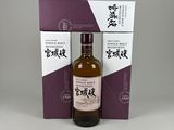 a bottle of japanese whisky in front of a purple and white box