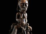 un gros plan sur la statue d'une personne assise sur un rocher