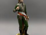une figurine ancienne représentant un homme muni d'une épée, posée sur un socle