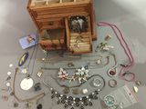 a wooden box filled with jewelry on a table