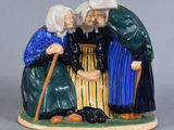deux figurines représentant des vieilles femmes assises sur un banc