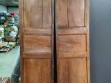 pair of antique wooden doors in a room with a wooden floor
