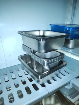 Plusieurs plats sont empilés sur une étagère dans un réfrigérateur