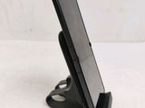 a cell phone that is on a stand on the table
