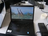 un ordinateur portable posé sur un bureau, à côté d'autres ordinateurs portables