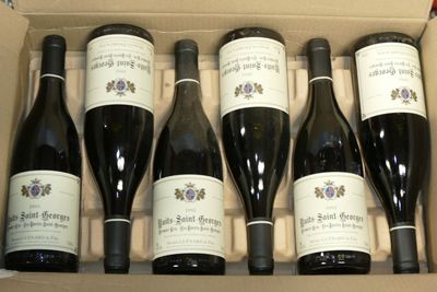 six bouteilles de vin dans un carton sur une table