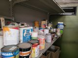 many cans of paint on a shelf in a room