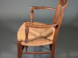 an image of a wooden chair with a woven seat on a grey background