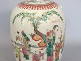 un vase blanc avec un tableau posé sur une table