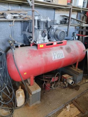 a red tank sitting in a room with a lot of tools
